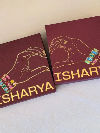 A pair of boxes with a heart-hands design, customized for the Isharya event.