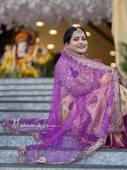 The bride posing on the steps, her beautiful saree and veil on full display.