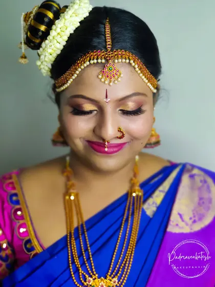 A close-up of another stunning Iyengar bride. The focus here is on the eyes, with golden shimmer eyeshadow and a sharp wing, paired with a bright pink lip for a classic bridal look.
