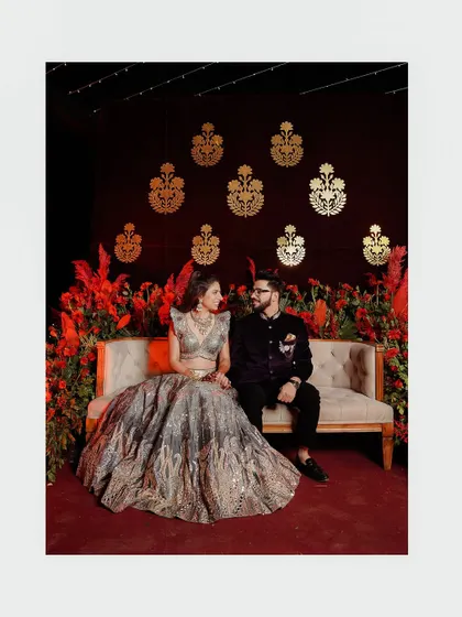 A portrait of the couple seated against a dramatic red and gold backdrop. This shot captures the opulence and theme of their Qawali night.