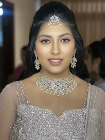 A smiling portrait of a client ready for an evening event. The makeup is glamorous yet feels fresh and modern, a style that is very popular for receptions and parties.