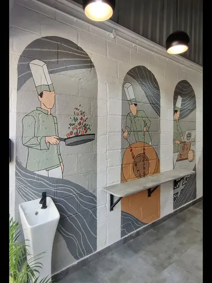 The full view of the three-panel chef mural, which adds a unique narrative element to the restaurant's dining space.