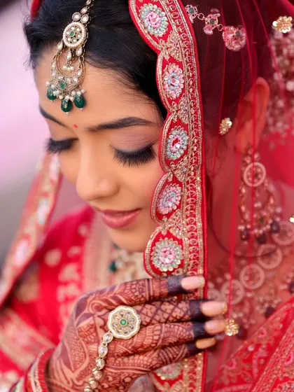 A detailed bridal portrait is essential. This close-up focuses on the intricate details of the bride's makeup, jewelry, and the delicate embroidery of her veil, showcasing her elegance and the quiet moments of anticipation.