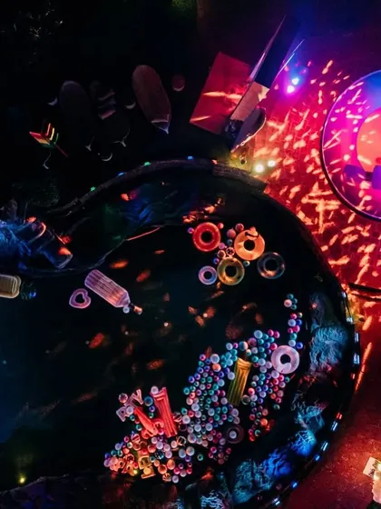 An aerial view of the after-party setup, showing the pool filled with floaters and the DJ stage lit up, ready for a night of celebration.