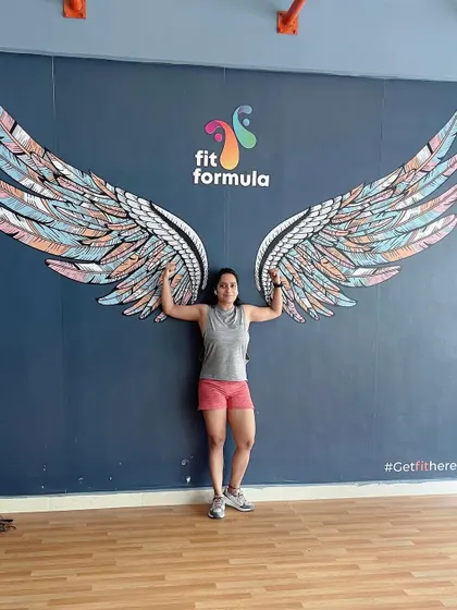 Another member of our community celebrating her strength. Our iconic wings wall is a favorite spot for members to capture their fitness progress.