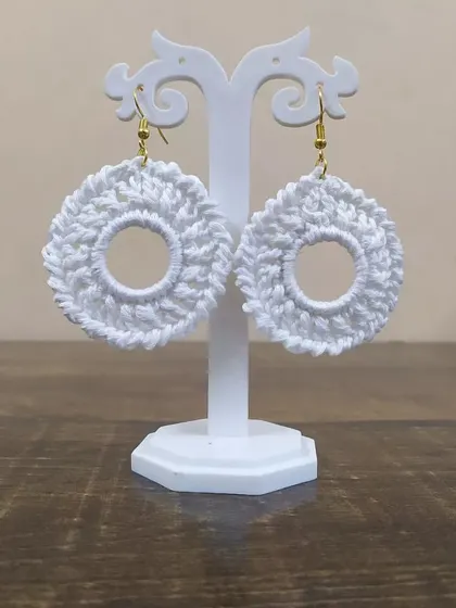 The white hoop earrings displayed on a stand. These handmade earrings are great for gift hampers or bridal party favors.