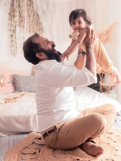 A father joyfully lifts his child in the air. These playful, high-energy moments are just as important to capture as the quiet ones.