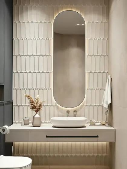 An elegant and minimalist bathroom vanity. The vertically stacked tiles behind the backlit oval mirror create a beautiful textural effect.