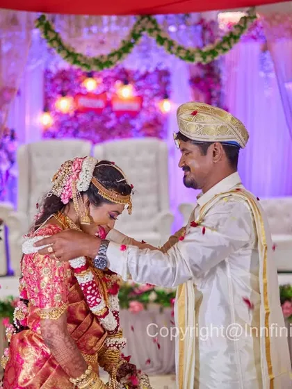 This is a classic shot of the Varmala ceremony, taken from a distance to include the beautifully decorated stage and the rich colors of their attire.