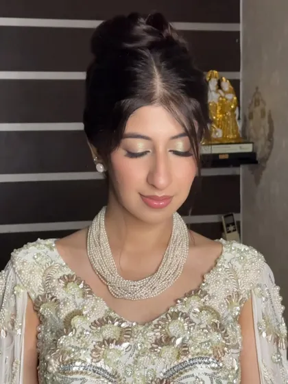 An elegant updo paired with a shimmery gold eye. This close-up shows how the hair and makeup work together to create a classic and timeless look.