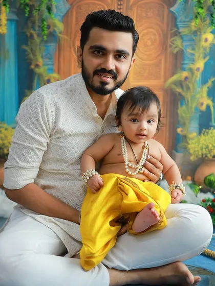 A father's pride and joy. This portrait of a dad holding his baby Krishna is a powerful testament to the special bond they share.