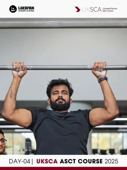 A participant executes a barbell overhead press, a fundamental strength movement analyzed during the practical sessions of Day 4.