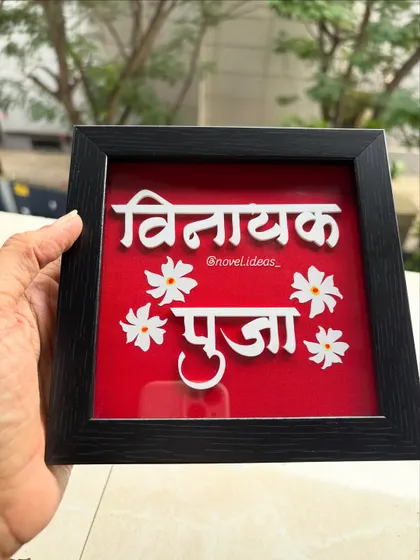 A slightly different angle of the 'Vinayak Pooja' name frame, showing how the light catches the 3D letters.