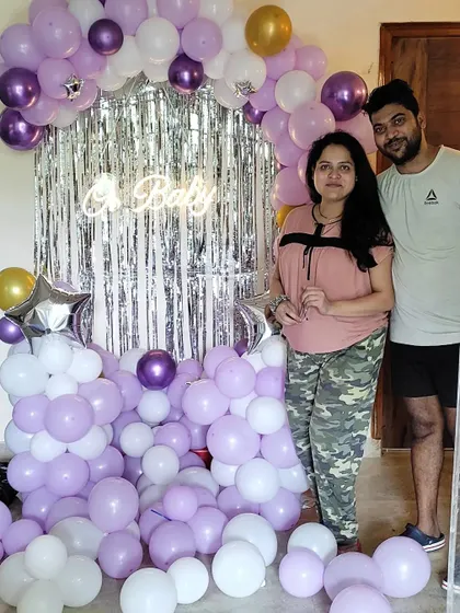 The happy couple posing with their completed baby shower decoration. We love capturing these joyful moments for our clients.