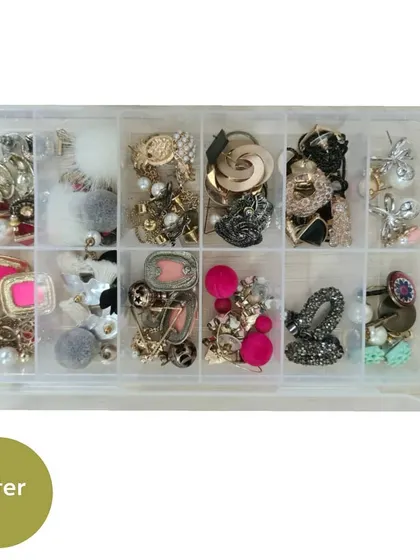 A close-up of a jewelry box used to organize small earrings and rings. This keeps them safe, untangled, and easy to see.