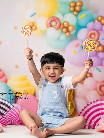 Two lollipops for a very happy birthday boy! This shot from our candy-themed session captures the playful energy and excitement of being a toddler.