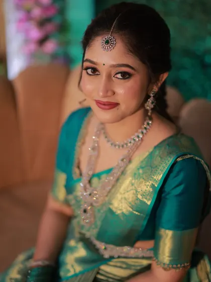 A close-up portrait showing the details of the makeup. The bride's skin looks luminous, and her eyes are beautifully defined, complemented by sparkling diamond jewellery.