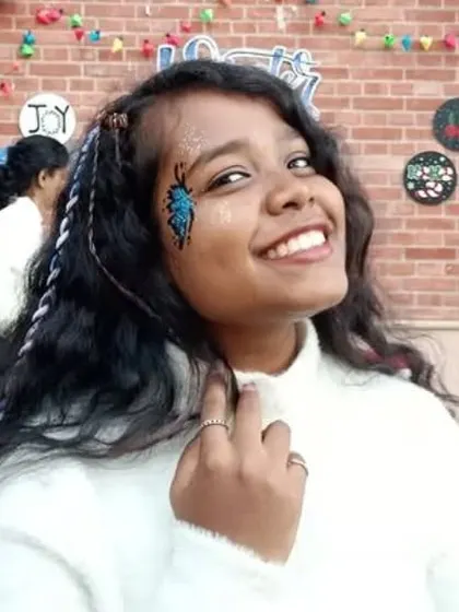A happy client showing off her bright blue beetle or winged insect design, full of sparkle and personality.