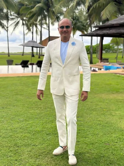 Another shot of the client in the off-white linen suit, walking with confidence. The relaxed tailoring and lightweight fabric make it ideal for warm climates.