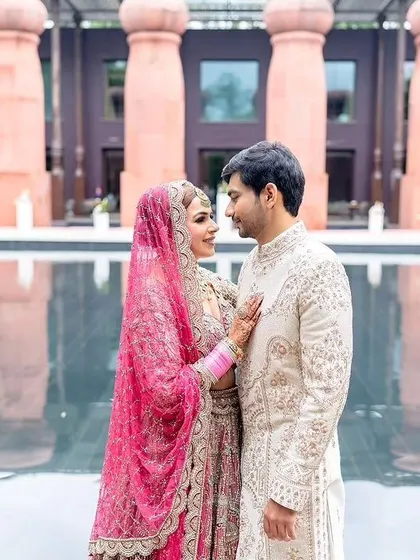 A stunning photo of the couple by the pool at their wedding venue.