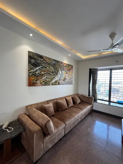 A wider shot of the living room, showing how the "Self Love" mural complements the brown and neutral tones of the furniture and decor.