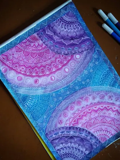 This is my 'Galaxy Mandala' series, where I blend intricate geometric patterns with the colors of deep space. Each section is carefully detailed with fine-line markers, transitioning from cosmic blues to vibrant purples and pinks to create a sense of depth and wonder.
