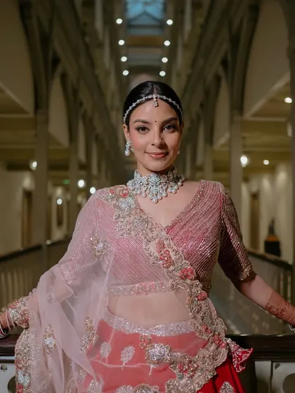A stunning portrait in the hotel corridor. The combination of her red and pink lehenga with the diamond jewelry is modern and elegant.