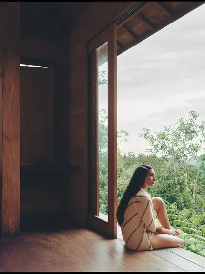 Contemplation by the window. The natural light and the simple, elegant lines of the tunic create a soft and tranquil mood.