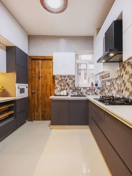 A wider view of the two-tone kitchen, showing the placement of the refrigerator and microwave unit, ensuring a seamless and integrated look.
