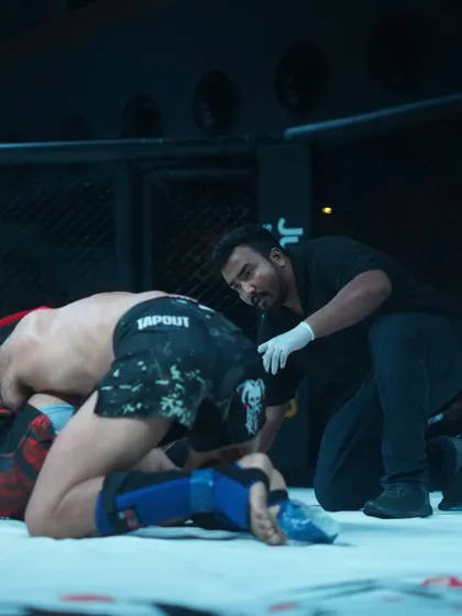 Checking on a fighter on the ground. My experience as a coach and fighter gives me a deep understanding of what's happening in the cage, which is crucial for a referee.