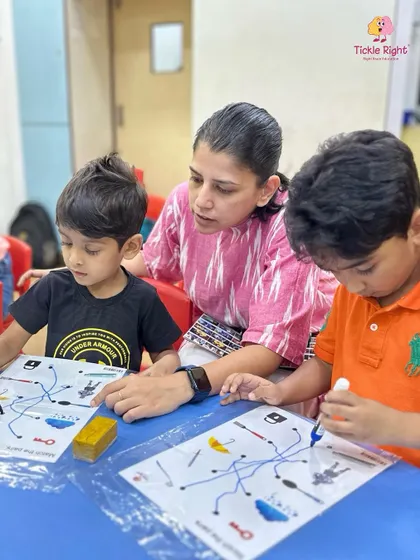Two boys work on a brain-boosting puzzle with their mother's help, an example of the challenging yet fun activities we use to develop logical thinking.