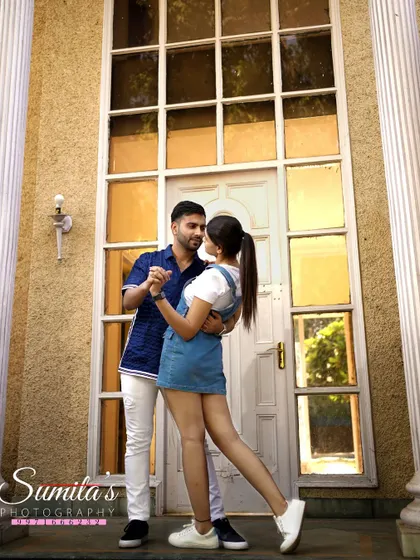 A classic dance pose in front of a grand window. This pre-wedding shot has a timeless, romantic feel, capturing a moment of shared joy.
