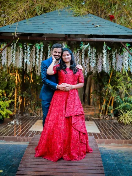 A beautiful couple posing in a picturesque location. She is wearing a stunning red lace gown, and he is in a classic blue suit, a timeless combination for a pre-wedding shoot.