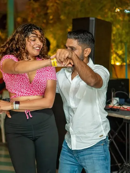 A stylish couple dancing near the DJ booth, right in the heart of the action. The energy here is always electric.