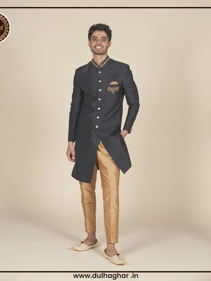 A black Indo-Western sherwani with gold trousers, offering a classic and opulent look.