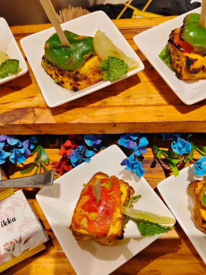 Our Stuffed Paneer Tikka is a feast of colors and flavors. Cubes of soft paneer are stuffed with a savory filling, marinated, and grilled, then served with a fresh mint chutney.