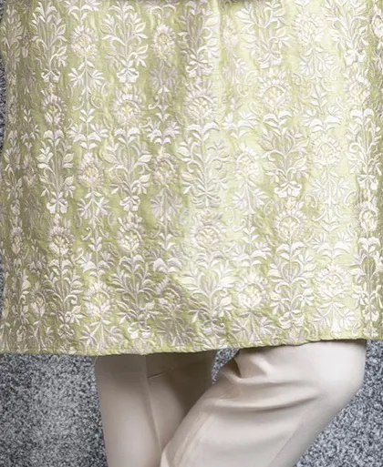 A detail shot of the hem of the mint green kurta, covered in matching Resham embroidery.