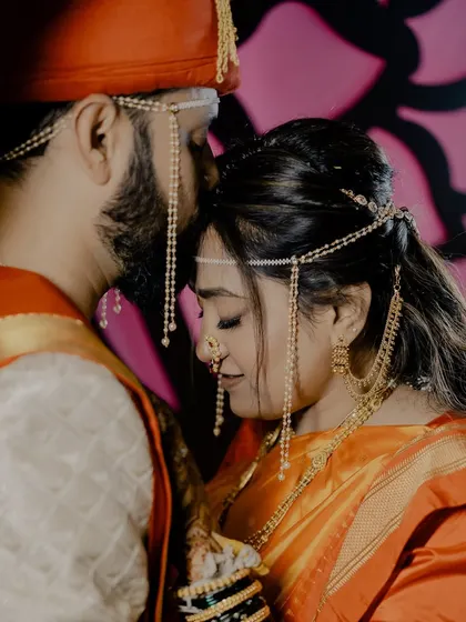 A tender moment with the groom kissing his bride's forehead.