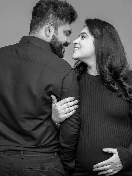 A classic black and white maternity portrait capturing a candid look between the couple. This style emphasizes their connection and the emotion of the moment.