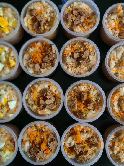 Meal prep day in the KuBi kitchen. Here’s a top-down view of our freshly cooked meals, portioned and ready for delivery. You can see the different toppings like boiled egg, soya chunks, and shredded carrots, showing the variety in each batch.