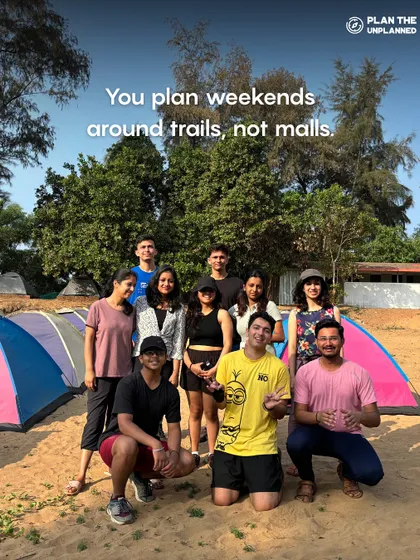 A group of friends camping on a beach. This image shows that you plan weekends around trails, not malls, which is the spirit of our community.