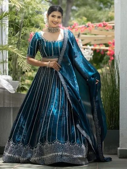 A full view of the stunning lehenga. The makeup is balanced to complement the rich color and intricate design of the outfit.