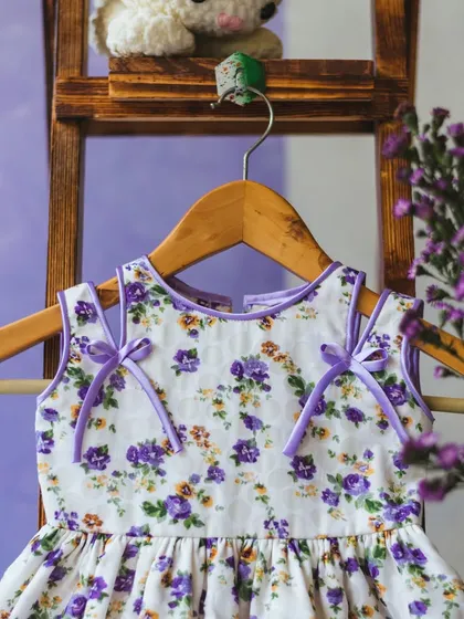 A sweet purple floral dress with delicate ribbon ties, perfect for twirls, giggles, and endless smiles.