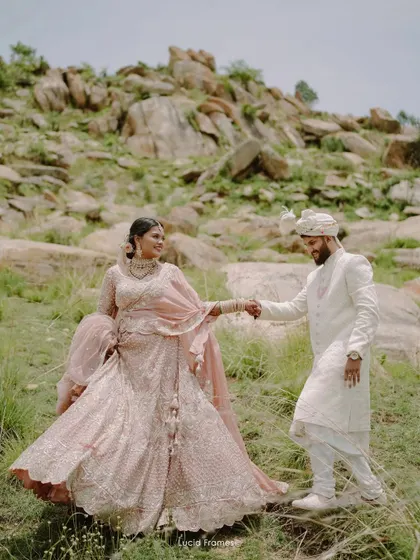 The bride's lehenga flows as they walk hand-in-hand, a perfect shot that combines fashion, movement, and romance.