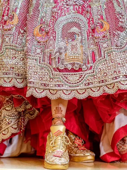 The bride's modern choice of footwear, peeking out from under her traditional lehenga.