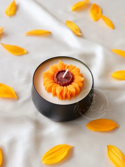 My Sunflower tin candle, with petals scattered around. It captures the happy essence of a sunflower.
