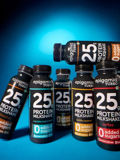 An exaggerated low-angle shot of Epigamia's protein milkshakes. This perspective makes the bottles look powerful and energetic, aligning with the "Turbo" branding and fitness-oriented audience.
