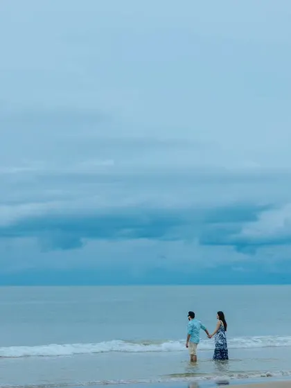 The couple walking hand-in-hand along the shoreline, a classic pre-wedding photograph that symbolizes the beginning of their journey together.
