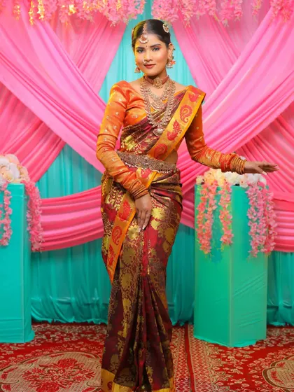A full-length shot of the bride, looking absolutely regal. The complete temple jewellery set adds a touch of grandeur to her beautiful silk saree.