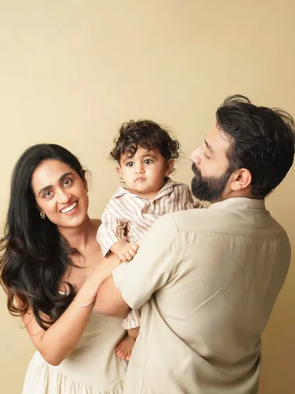 A candid family moment, with the parents looking at their son. The natural interaction makes this portrait feel authentic and full of love.